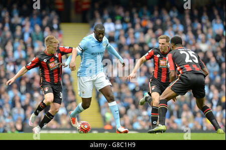 Yaya Toure de Manchester City combat pour le ballon avec Matt Ritchie (à gauche), Dan Gosling (deuxième à droite) et Sylvain Distin de l'AFC Bournemouth lors du match de la Barclays Premier League au Etihad Stadium de Manchester. Banque D'Images