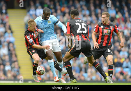 Yaya Toure de Manchester City combat pour le ballon avec Matt Ritchie (à gauche), Dan Gosling (à droite) et Sylvain Distin de l'AFC Bournemouth lors du match de la Barclays Premier League au Etihad Stadium de Manchester. Banque D'Images