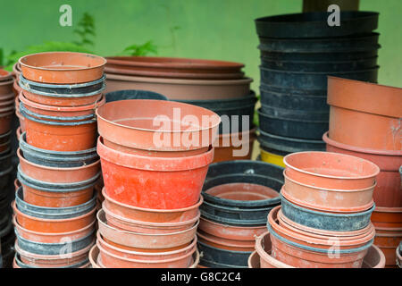 Pots en plastique vides empilées sur une étagère dans un polytunnel. Banque D'Images