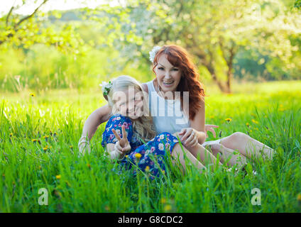 Petite fille et Maman récolte des pommes. Portrait de jeune fille mère heureuse et avec coeur. Banque D'Images