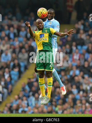 Yaya Toure de Manchester City (à droite) lutte pour le ballon avec Youssouf Mulumbu de Norwich City lors du match de la Barclays Premier League au Etihad Stadium, Manchester. Banque D'Images