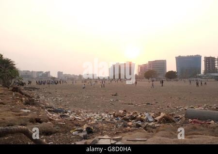 Les enfants de la rue et les adultes jouer au cricket dans le B.K.C. Le Bandra Kurla Complex, Bandra East, Mumbai, Maharashtra, Inde Banque D'Images