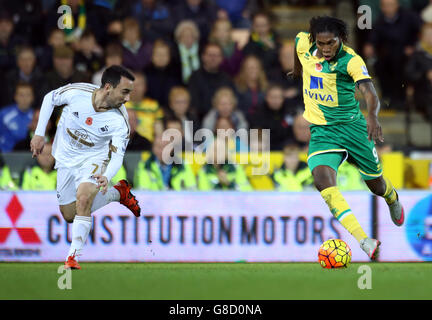 Dieumerci Mbokani de Norwich City est défié par Leon Britton (à gauche) de Swansea City lors du match de la Barclays Premier League à Carrow Road, Norwich. Banque D'Images