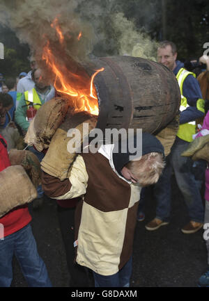 Un enfant du village du Devonshire d'Ottery St Mary porte le Tar Barrel traditionnel dans les rues du village la nuit de Bonfire. Banque D'Images