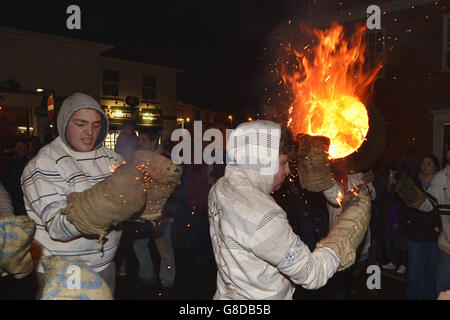 Les adultes du village Devonshire d'Ottery St Mary portent le Tar Barrel traditionnel à travers les rues du village la nuit de Bonfire. Banque D'Images