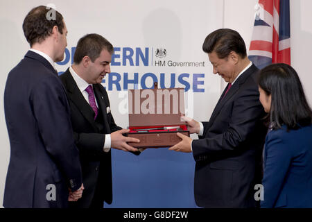 Le chancelier George Osborne (à gauche) regarde le président de la République populaire de Chine M. Xi Jinping (à droite) présente des pinceaux au professeur Sir Kostya Novaselav, qui se voit accorder une visite de l'Institut national du graphène à Manchester. Banque D'Images