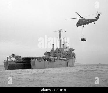 Un hélicoptère de la Royal Air Force transportant un Land Rover de l'Armée se déplace pour le placer sur le pont du nouveau navire d'assaut de la Royal Navy, le HMS Fearless, lors d'une démonstration de la polyvalence du navire au large de Lee-on-Solent, Hampshire. Sans peur est le premier navire d'atterrissage d'assaut de la marine britannique et peut transporter environ 400 soldats avec un nombre important de chars, de véhicules et d'équipement lourd. Banque D'Images