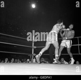 Le Challenger Brian London (l) tire une gauche à la mâchoire de Muhammad Ali lors du premier tour du Championnat du monde de poids lourd à Earls court Arena, Londres. Banque D'Images