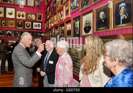 Le Prince de Galles parle aux descendants des premiers colons, dont les photos ornent les murs du Settlers Museum, dans la ville de Dunedin, sur l'île sud de la Nouvelle-Zélande. Banque D'Images