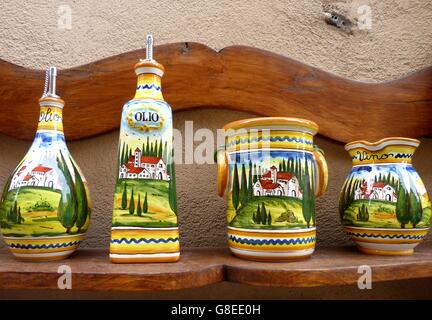 Toscan traditionnel coloré Condiment en céramique peint des conteneurs sur une planche en bois. Banque D'Images