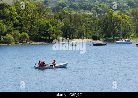 Bateau à rames de voitures, avec un groupe de trois personnes à bord, sur l'Ullswater, le deuxième plus long Lake dans le Lake District Banque D'Images