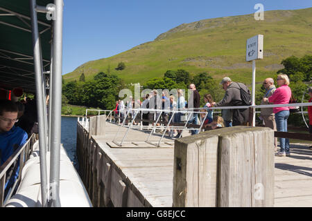 Les passagers se regroupent sur Ullswater Steamers Howtown pier, Cumbria, prêt pour l'arrivée du paquebot à voile Glenridding. Banque D'Images