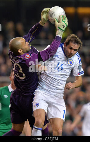 Le gardien de but de la République d'Irlande Darren Randolph (à gauche) rassemble le ballon sous le défi de Senad Lulic (à droite) de Bosnie-Herzégovine lors de la deuxième étape de l'UEFA Euro 2016 Qualificative Playoff au stade Aviva, à Dublin. Banque D'Images