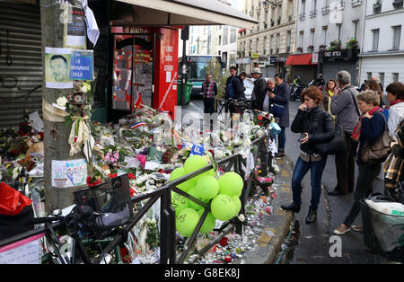 Les foules se rassemblent pour observer les hommages floraux et les bougies laissées au bar la Belle Equipe à Paris, après que les attaques terroristes ont tué au moins 129 personnes dans la ville vendredi. Banque D'Images