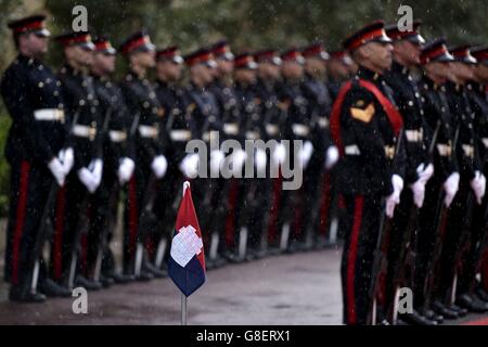 Le drapeau maltais vole à côté d'une garde d'honneur sur le tapis rouge du Palais San Anton à Attard, avant l'arrivée de la reine Elizabeth II pour la Réunion des chefs d'État du Commonwealth (CHOGM) à Malte. Banque D'Images