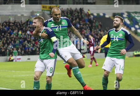 Steven Davis, d'Irlande du Nord, célèbre avec ses coéquipiers Josh Magennis (au centre) et Stuart Dallas, après avoir marquant le premier but de son équipe lors d'un match international contre la Lettonie à Windsor Park, Belfast. Banque D'Images