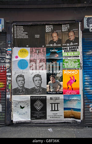 Diverses affiches sur un mur à Redchurch Street, Shoreditch, East London, UK. Banque D'Images