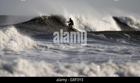 Un surfeur passe les vagues à Tynemouth, Tyne et Wear, North Tyneside, comme le pire de Storm Barney a passé dans la plupart des régions, les températures sont réglées pour baisser à 0 C (33,8 F) samedi, avec des vents élevés qui le font sentir aussi bas que -4C (24.8) dans certaines parties. Banque D'Images
