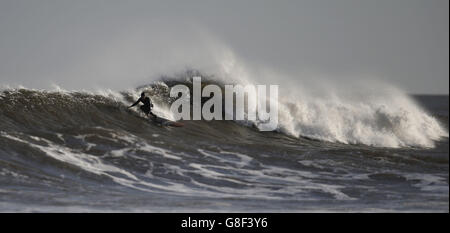 Un surfeur passe les vagues à Tynemouth, Tyne et Wear, North Tyneside, comme le pire de Storm Barney a passé dans la plupart des régions, les températures sont réglées pour baisser à 0 C (33,8 F) samedi, avec des vents élevés qui le font sentir aussi bas que -4C (24.8) dans certaines parties. Banque D'Images