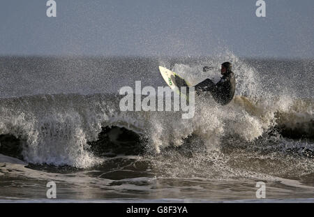 Un surfeur passe les vagues à Tynemouth, Tyne et Wear, North Tyneside, comme le pire de Storm Barney a passé dans la plupart des régions, les températures sont réglées pour baisser à 0 C (33,8 F) samedi, avec des vents élevés qui le font sentir aussi bas que -4C (24.8) dans certaines parties. Banque D'Images