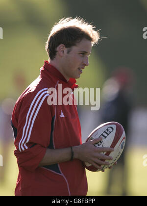 Le Prince William tient le ballon lors d'une séance d'entraînement le vendredi 1er juillet 2005, avec l'entraîneur de coups de pied des Lions britanniques et irlandais Dave Alred, et vole la moitié de Charlie Hodgson, au sol de la réserve de Basin à Wellington. Banque D'Images