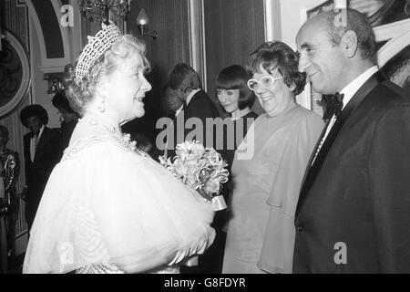 La reine Elizabeth, la reine mère, rencontre Warren Mitchell et Dandy Nichols de Till Death US Do part après la Royal Variety Performance de ce soir au London Palladium, una Stubbs, qui joue la fille, est à côté d'eux. Banque D'Images