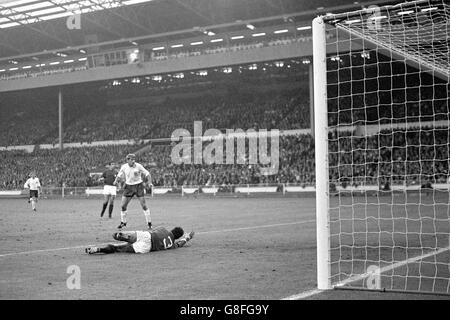 Football - coupe du monde Angleterre 1966 - semi finale - Portugal / Angleterre - Stade Wembley.Roger Hunt d'Angleterre regarde comme le gardien de but portugais Jose Pereira (sur le sol) est battu pour le deuxième but de l'Angleterre Banque D'Images