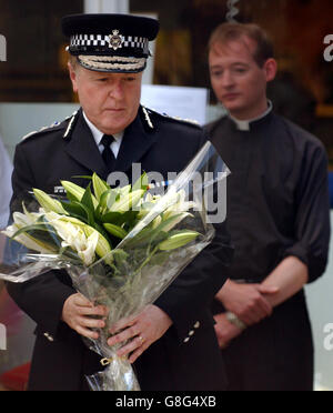 Sir Ian Blair, commissaire de la police métropolitaine, lors d'une visite à la gare de Kings Cross, dans le centre de Londres, où il a déclaré que le nombre de morts augmenterait en rendant hommage aux secouristes. Sir Ian, qui portait un grand bouquet de lys blancs, s'est mis en pause pour réfléchir avant de rencontrer des personnalités religieuses sur le site d'hommage floral juste à l'extérieur de la gare de King's Cross. Il a dit qu'il venait juste de l'une des scènes de l'attentat à Russell Square. Banque D'Images