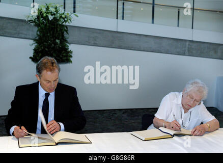Le Premier ministre britannique Tony Blair signe le Livre de Condorence pour les victimes des attentats terroristes de la semaine dernière, aux côtés d'un membre du public Jean Vallaton. Banque D'Images