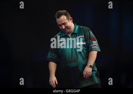 Brendan Dolan réagissant pendant le premier match du deuxième jour du Championnat du monde William Hill PDC à Alexandra Palace, Londres. Banque D'Images