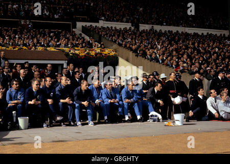 Les deux bancs regardent le match : (l-r) Dr H Schoberth, ?, entraîneur adjoint Dettmar Cramer, entraîneur Helmut Schon et entraîneur adjoint Udo Lattek, et entraîneur d'Angleterre les Cocker, ?, gérant Alf Ramsey, physio Harold Shepherdson et membre de l'équipe Jimmy Greaves.Les membres de l'équipe d'Angleterre George Eastham (r), Ron Springett (deuxième r), Peter Bonetti (troisième r), Ian Callaghan (assis derrière Ramsey), Gerry Byrne (derrière Cocker) et Jimmy Armfield (devant Callaghan) Banque D'Images