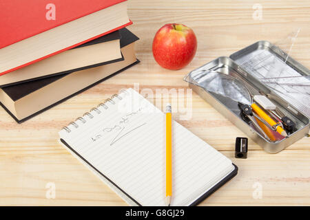 Bureau de l'école avec un bloc-notes ouvert montrant 1er jour de terme avec quelques livres de texte, taille-crayon et Apple Banque D'Images