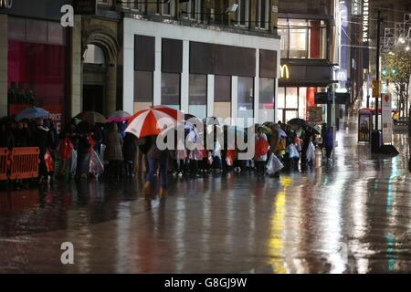 Les clients font la queue sous la pluie pour entrer dans un magasin Next du centre-ville de Liverpool au fur et à mesure que les ventes du lendemain de Noël se font. Banque D'Images