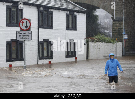 Les gens se sont empais dans les eaux inondées à Mytholmroyd à Caldernon, dans le West Yorkshire, où les sirènes des crues ont été sondées après des averses torrentielles. Banque D'Images