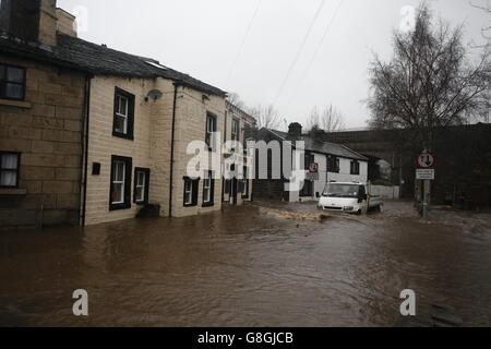 Un véhicule traverse les eaux d'inondation à Mytholmroyd, à Caldove, dans le West Yorkshire, où les sirènes d'inondation ont été sondées après des détrots torrentiels. Banque D'Images