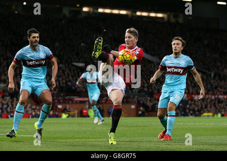 Le Bastian Schweinsteiger de Manchester United (au centre) libère le ballon loin de James Tomkins (à gauche) de West Ham United et de Mark Noble lors du match de la Barclays Premier League à Old Trafford, Manchester. Banque D'Images