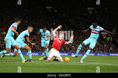 Le Bastian Schweinsteiger de Manchester United (au centre) est lancé par Alex Song de West Ham United (au centre à gauche) lors du match de la Barclays Premier League à Old Trafford, Manchester. Banque D'Images