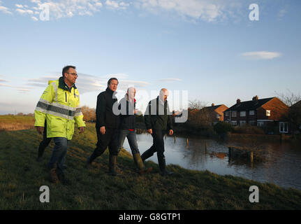 Le Premier ministre David Cameron (troisième à droite) se voit en défense contre les inondations lors d'une visite dans la ville de Carlisle, à Cumbria, touchée par les inondations. Banque D'Images