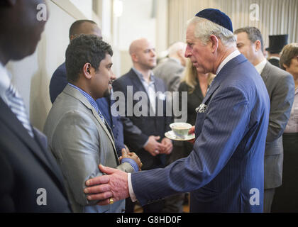 Le Prince de Galles rencontre Vithyavarun Patkunalingam (à gauche), un réfugié aidé par le programme bénévole et social de la synagogue, qui marque le 175e anniversaire de la synagogue de Londres-Ouest en assistant à un service spécial de 'siyyum' suivi d'une réception pour les membres de la congrégation à Londres. Banque D'Images