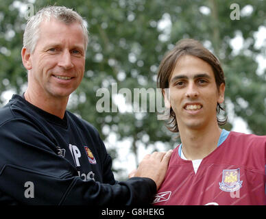 Alan Pardew (L), directeur de West Ham United, et Yossi Benayoun, nouveau signataire lors d'un appel photo. Banque D'Images