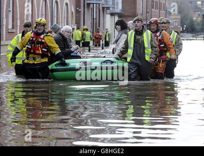 Les membres de l'armée et les équipes de secours aident à évacuer les personnes des propriétés inondées après avoir été piégées par la montée des eaux lorsque la rivière Ouse éclate sur ses rives dans le centre-ville de York. Banque D'Images