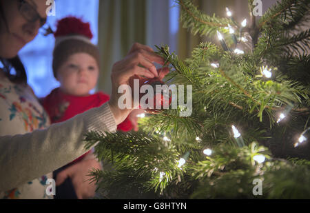 Charlotte Rose, âgée de 10 mois, regarde des boules sur un arbre de Noël, London PRESS ASSOCIATION photo. Date de la photo: Dimanche 13 décembre 2015. Le crédit photo devrait se lire : Anthony Devlin/PA Wire Banque D'Images