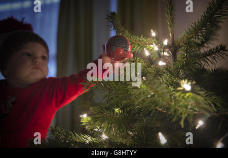 Charlotte Rose, âgée de 10 mois, touche une boule sur un arbre de Noël, London PRESS ASSOCIATION photo. Date de la photo: Dimanche 13 décembre 2015. Le crédit photo devrait se lire : Anthony Devlin/PA Wire Banque D'Images