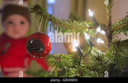 Charlotte Rose, âgée de 10 mois, regarde les boules et les vols de fées sur un arbre de Noël, London PRESS ASSOCIATION photo. Date de la photo: Dimanche 13 décembre 2015. Le crédit photo devrait se lire : Anthony Devlin/PA Wire Banque D'Images