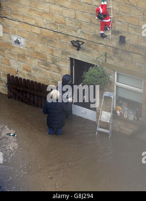 Les résidents évacuent une maison à Mytholmroyd, à Calvaire, dans le West Yorkshire, où des sirènes d'inondation ont été sondées après des détrots torrentiels. Banque D'Images