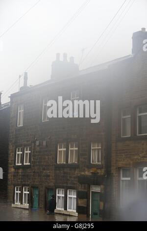 Un homme traverse les eaux d'inondation à Mytholmroyd, à Caldove, dans le West Yorkshire, où des sirènes d'inondation se sont fait entendre après des détrots torrentiels. Banque D'Images