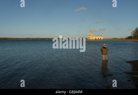 Pêcheur à la ligne Ade Naylor pêche en face de l'église Normanton au réservoir d'eau de Rutland à Rutland. Banque D'Images