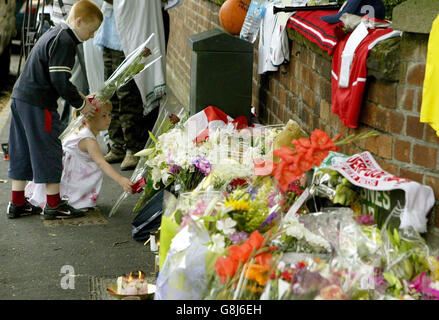 Les enfants labouent des fleurs près de l'endroit où Anthony Walker, 18 ans, a été assassiné vendredi soir dans la région de Huyton à Liverpool. Banque D'Images