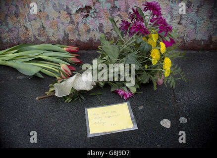 Les fleurs sont laissées sous une fresque de David Bowie sur le mur d'un magasin de Morley à Brixton, Londres, le lieu de naissance des chanteurs, après la mort de la rock star après une bataille de 18 mois contre le cancer. Banque D'Images