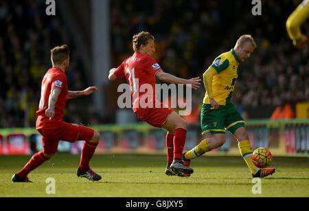 Steven Naismith (à droite) de Norwich City et Lucas Leiva (au centre) de Liverpool se battent pour le ballon lors du match de la Barclays Premier League à Carrow Road, Norwich. Banque D'Images